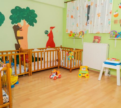 Ήσυχη αίθουσα ύπνου για βρέφη με ξύλινες κούνιες και ασφαλές περιβάλλον ανάπαυσης.