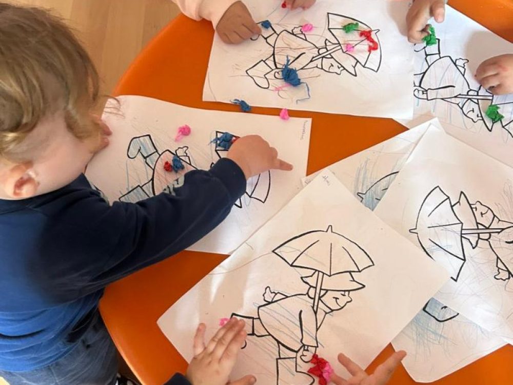 Παιδιά στο Μεταβρεφικό ζωγραφίζουν σε ομαδικό τραπέζι αναπτύσσοντας λεπτή κινητικότητα.